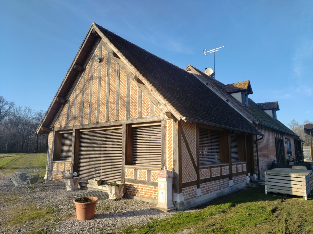 Vue extérieure d’une extension bois intégrée à une maison traditionnelle en Sologne.