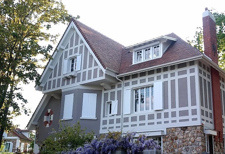 Maison à colombages rénovée avec 145 mm d’isolation entre chevrons, 140 mm d’isolation extérieure et habillages bois périphériques peints en blanc.