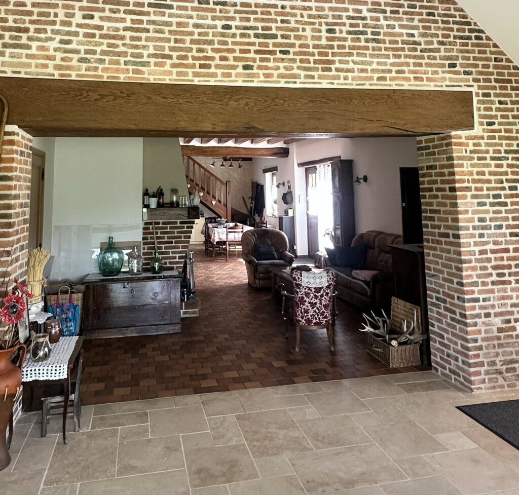 Grande ouverture créée dans un mur existant pour relier une maison ancienne à son extension.