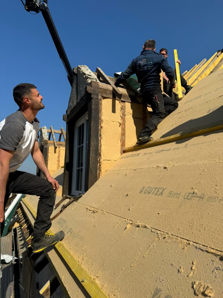 Isolation par l'extérieur en cours de réalisation autour d'une lucarne.