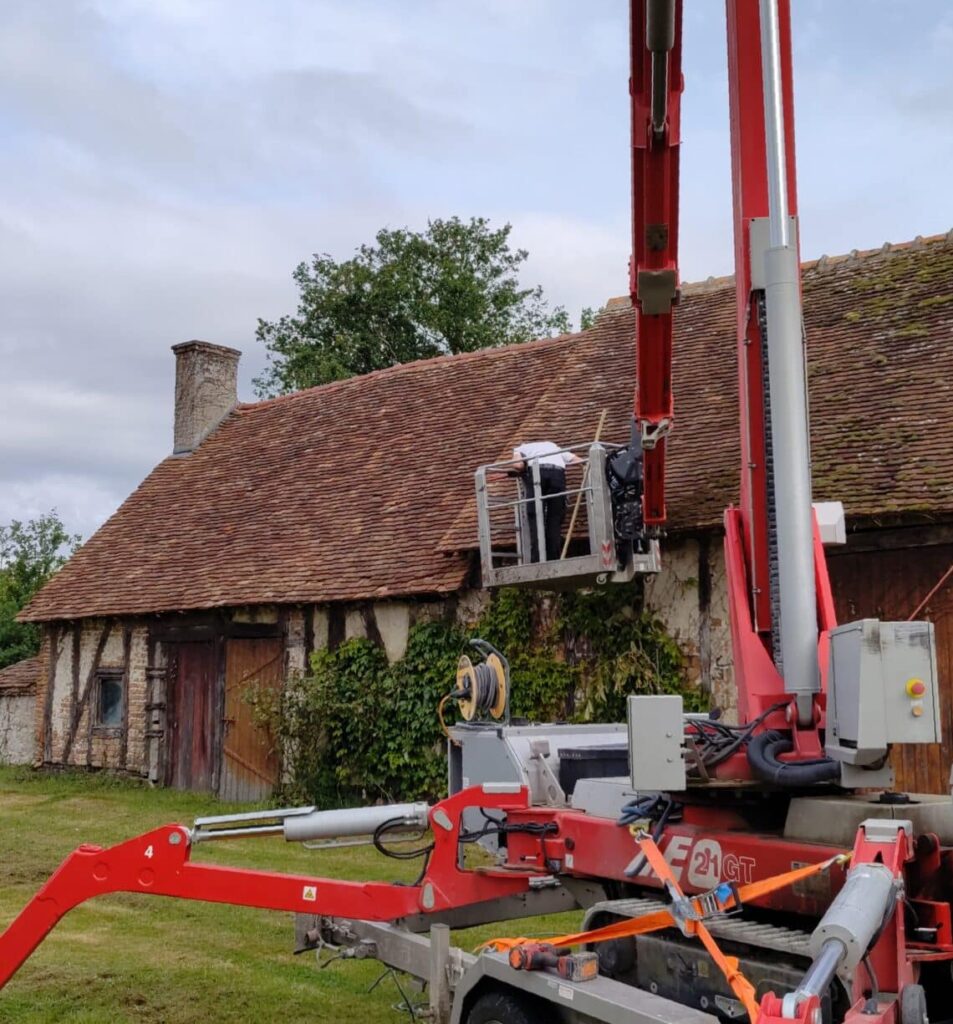 Démoussage de toiture ancienne avec nacelle