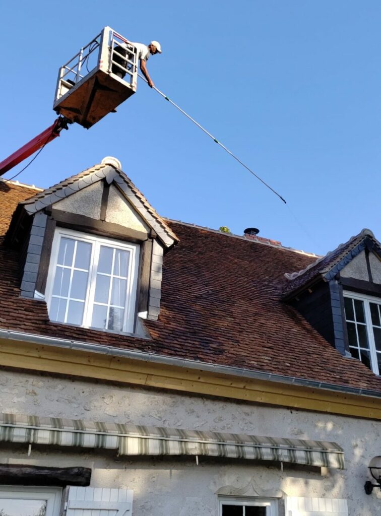 Application d’un traitement anti-mousse sur toiture depuis une nacelle